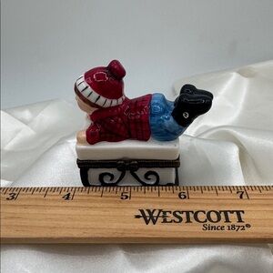 Porcelain Hinged Trinket Box of a Boy on a Sled.
Inside-a pair of red mittens!